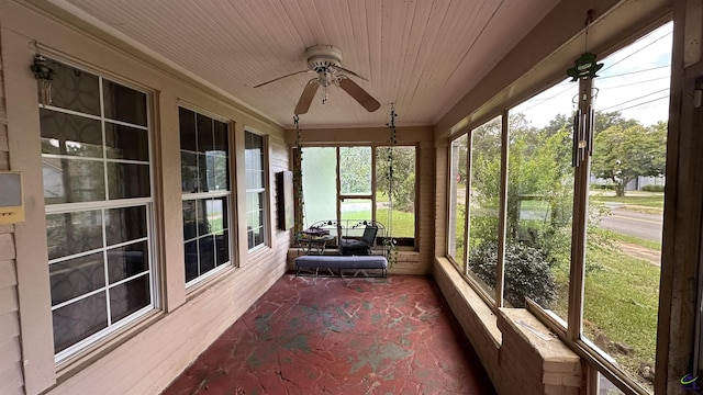 unfurnished sunroom featuring wood ceiling and a ceiling fan