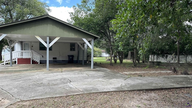 view of front of property featuring driveway, crawl space, and a detached carport