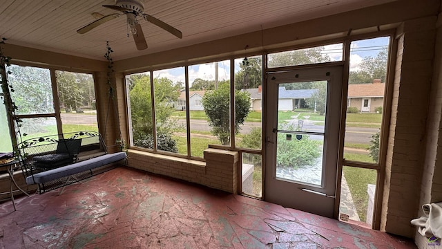 unfurnished sunroom with wood ceiling and ceiling fan