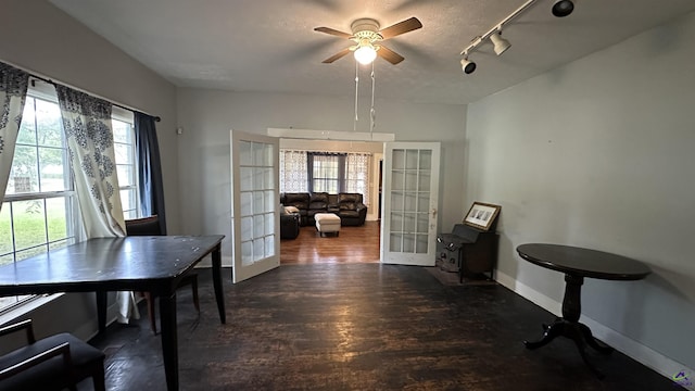 dining space featuring baseboards, a ceiling fan, dark wood-type flooring, rail lighting, and french doors