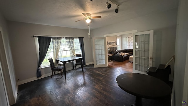 office with dark wood-style floors, french doors, a textured ceiling, and baseboards