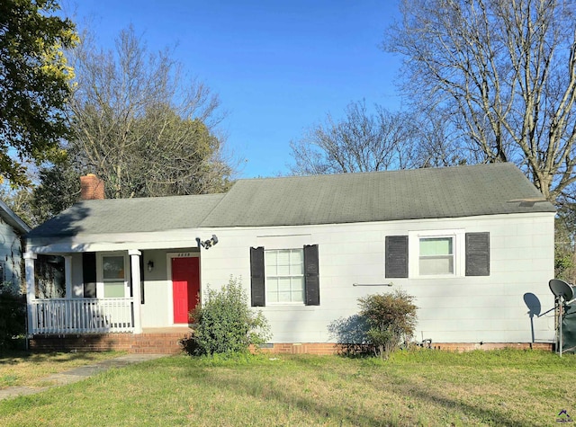 ranch-style house with a chimney, a front lawn, and a porch