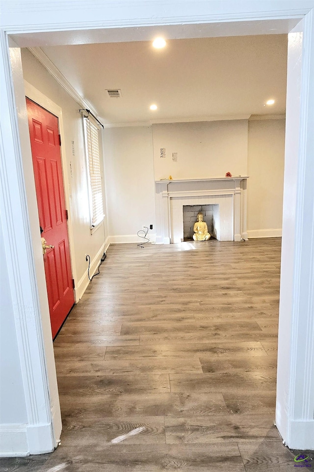 unfurnished living room featuring recessed lighting, wood finished floors, visible vents, baseboards, and ornamental molding