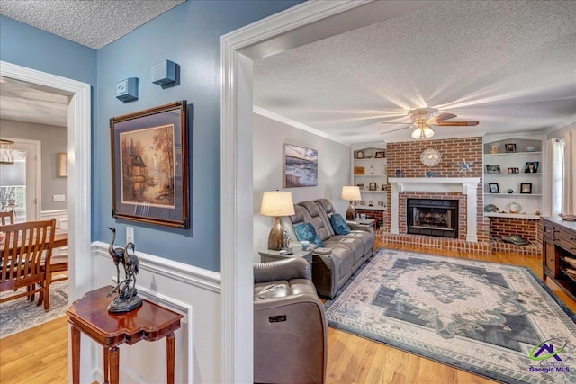 living room with built in features, a textured ceiling, and wood finished floors