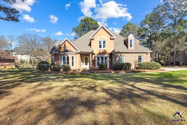 view of front of home with a front yard and roof with shingles