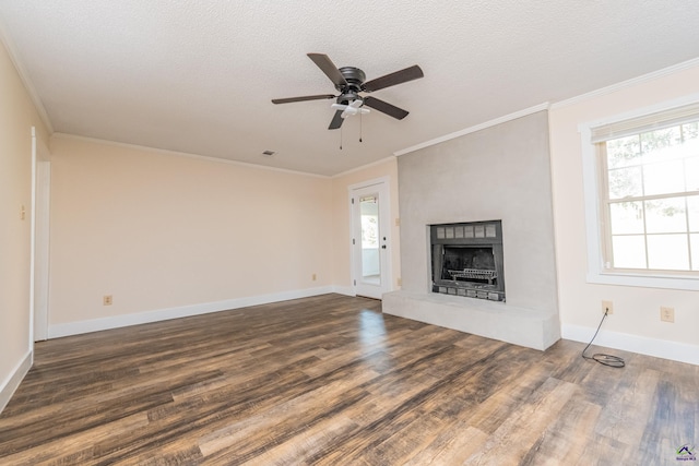 unfurnished living room with a fireplace with raised hearth, a textured ceiling, dark wood-style flooring, baseboards, and crown molding