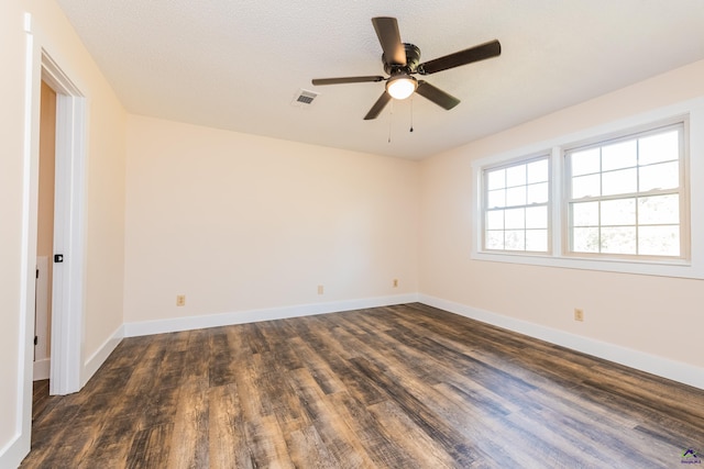 unfurnished room featuring dark wood-style floors, baseboards, and visible vents