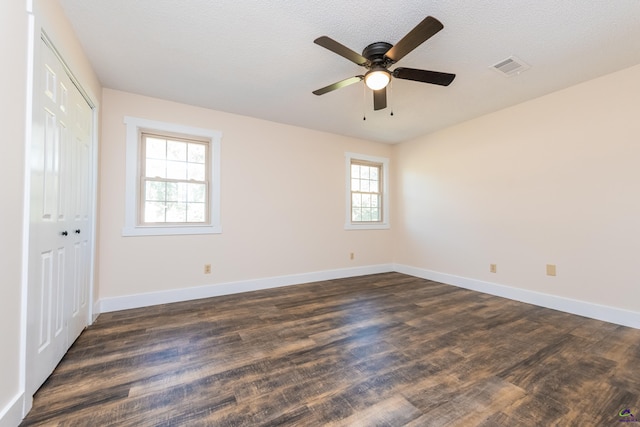 unfurnished bedroom featuring dark wood-type flooring, visible vents, and baseboards