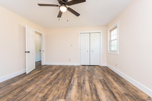 unfurnished bedroom featuring ceiling fan, a closet, baseboards, and dark wood-type flooring