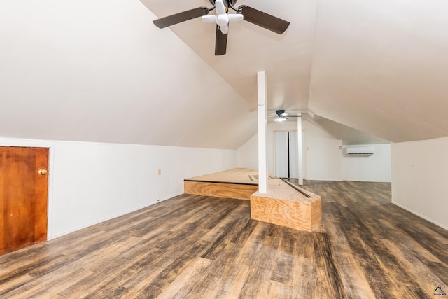 additional living space with lofted ceiling, dark wood-type flooring, and a wall unit AC