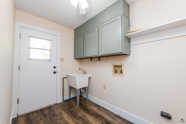 laundry area featuring cabinet space, baseboards, dark wood-type flooring, a textured ceiling, and washer hookup