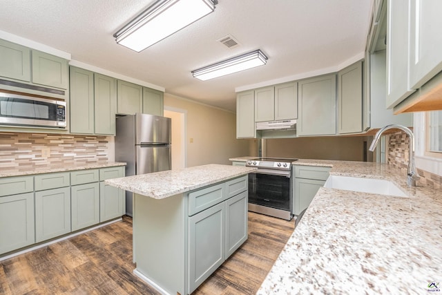 kitchen with light stone countertops, visible vents, appliances with stainless steel finishes, and a sink