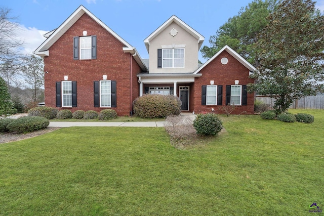 traditional home featuring brick siding, a front lawn, and fence