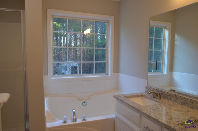 full bathroom with a garden tub, a shower, and vanity