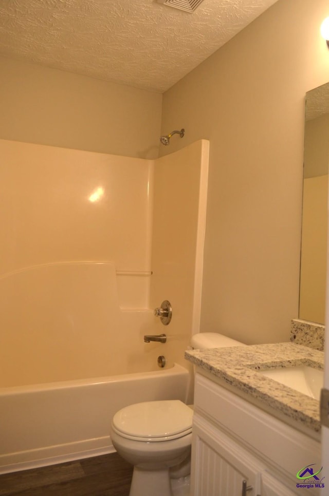 full bathroom featuring shower / bath combination, toilet, a textured ceiling, vanity, and wood finished floors