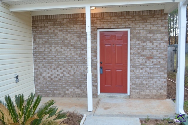 view of exterior entry featuring brick siding