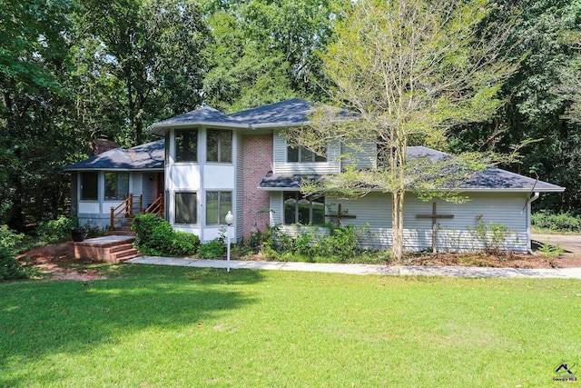 view of front of property with a front lawn, a chimney, and a sunroom