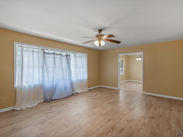 empty room with light wood-style floors, ceiling fan, and baseboards