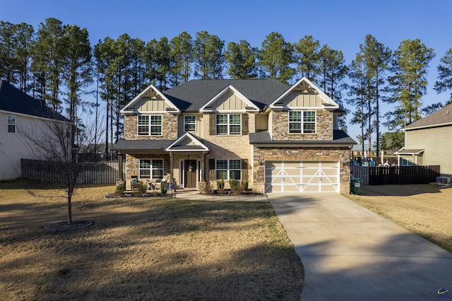 craftsman inspired home featuring a garage, fence, concrete driveway, stone siding, and board and batten siding