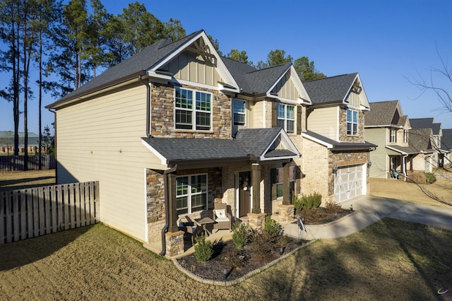 craftsman house with stone siding, board and batten siding, fence, and roof with shingles