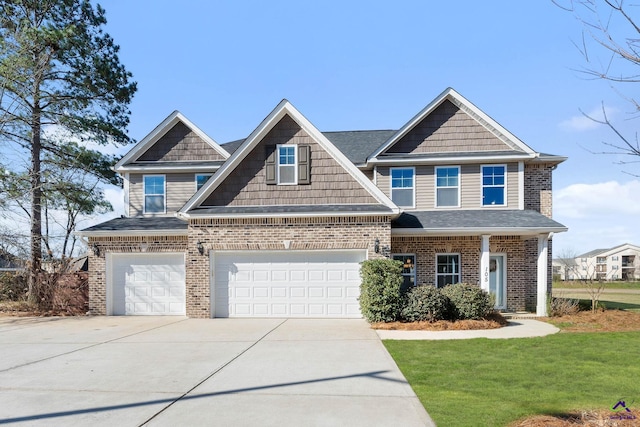 craftsman-style house with a garage, brick siding, a shingled roof, concrete driveway, and a front lawn