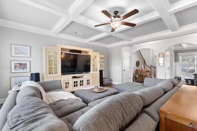 living room with arched walkways, stairs, and beam ceiling