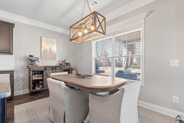 dining space featuring dark wood-style floors, baseboards, visible vents, and crown molding