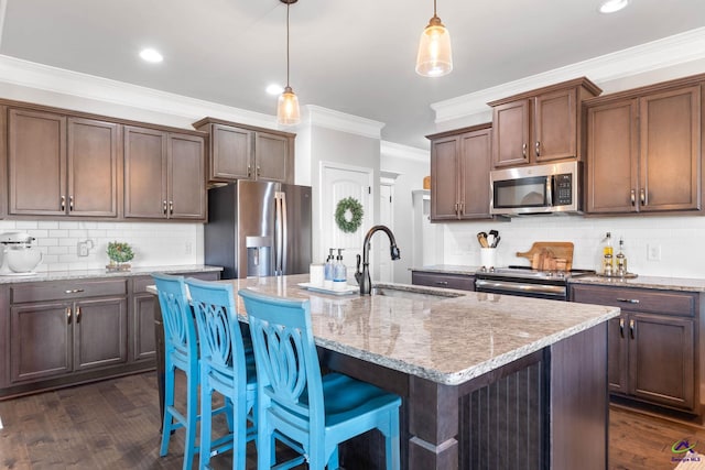 kitchen with dark wood finished floors, ornamental molding, light stone countertops, stainless steel appliances, and a sink