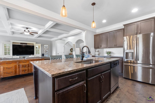 kitchen featuring dark wood-style floors, appliances with stainless steel finishes, arched walkways, and a sink