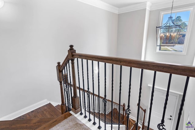 stairway featuring baseboards, an inviting chandelier, wood finished floors, and crown molding