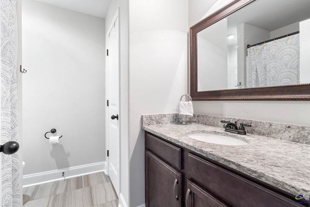 full bath with baseboards and vanity