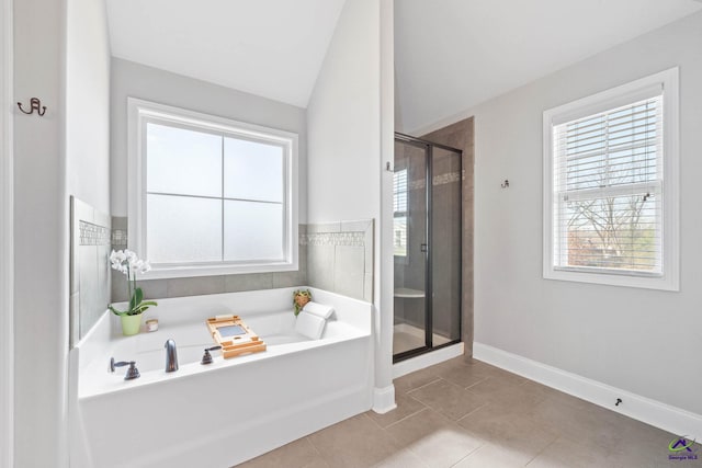 bathroom with a garden tub, baseboards, vaulted ceiling, a shower stall, and tile patterned floors