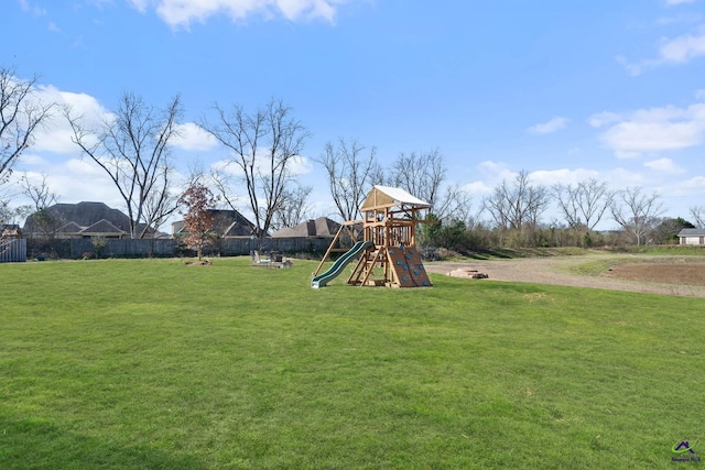 view of playground featuring a lawn and fence