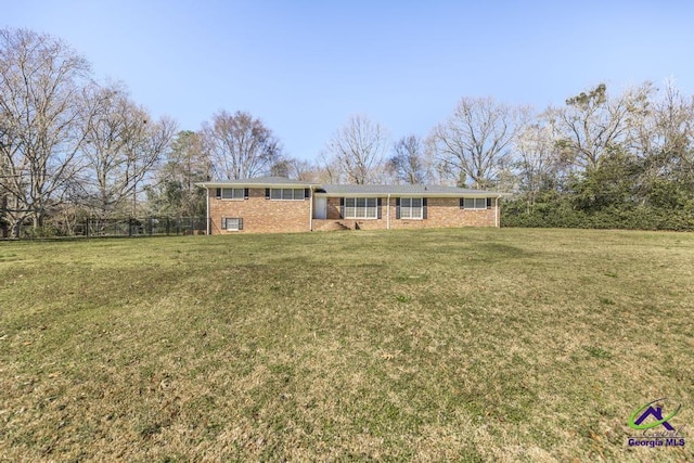 single story home featuring fence, a front lawn, and brick siding