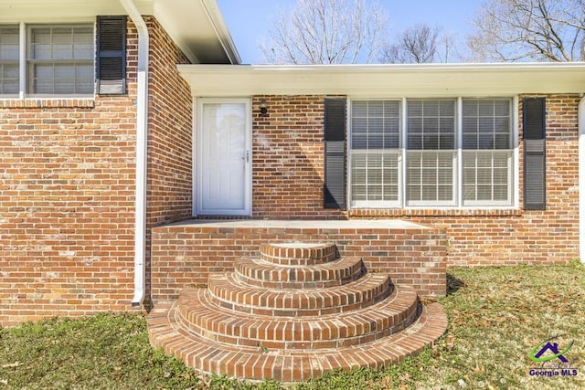 property entrance featuring brick siding