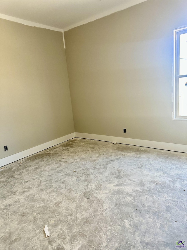 unfurnished room with crown molding and baseboards