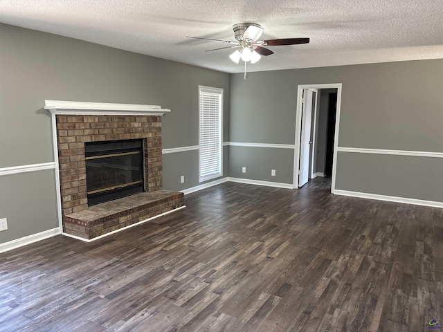 unfurnished living room featuring ceiling fan, a brick fireplace, dark wood finished floors, and baseboards