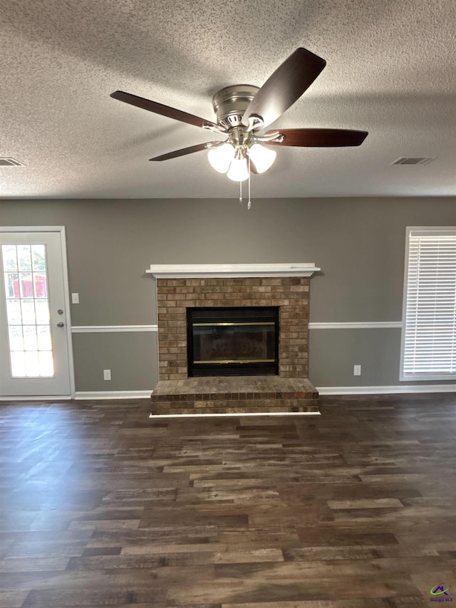 unfurnished living room with a fireplace, wood finished floors, and visible vents