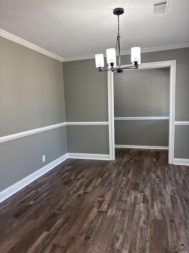 unfurnished dining area with a chandelier, a textured ceiling, dark wood-type flooring, visible vents, and ornamental molding