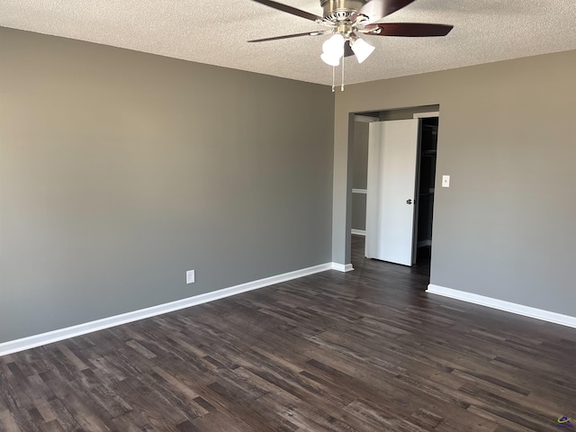 empty room featuring dark wood-style floors, ceiling fan, a textured ceiling, and baseboards