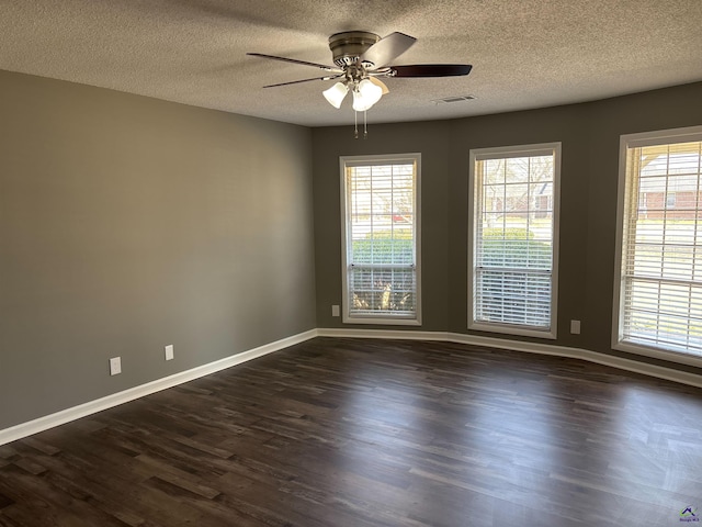 unfurnished room featuring dark wood-style floors, visible vents, a ceiling fan, a textured ceiling, and baseboards