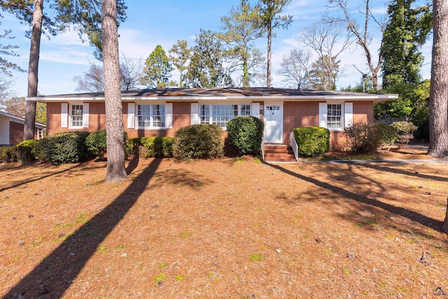 ranch-style home featuring entry steps and brick siding