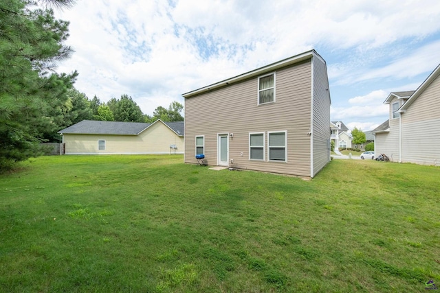 rear view of house featuring a yard