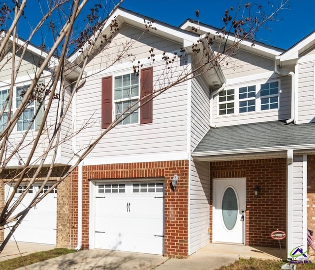 view of front of property featuring concrete driveway, brick siding, an attached garage, and a shingled roof