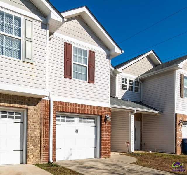 view of front of home with brick siding, driveway, and an attached garage