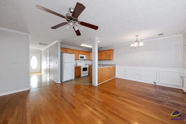 unfurnished living room featuring a textured ceiling, ornamental molding, and wood finished floors