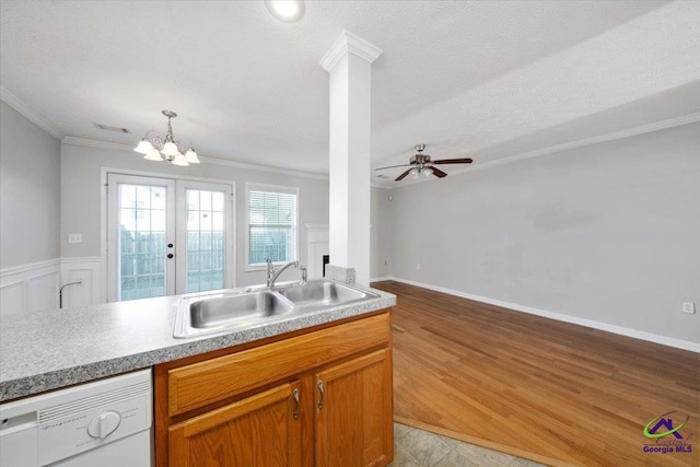 kitchen with crown molding, light wood-style flooring, white dishwasher, a sink, and ceiling fan with notable chandelier