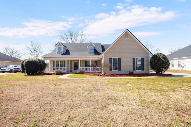 new england style home featuring covered porch and a front lawn