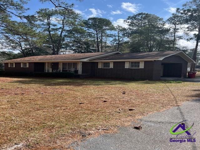 single story home with aphalt driveway and a front yard