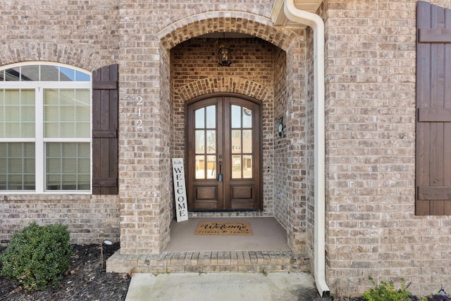 entrance to property featuring brick siding and french doors